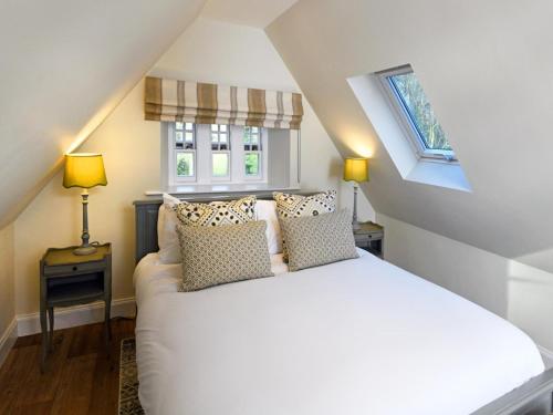 a bedroom with a white bed and two windows at 3 Bed in Lockerbie oc-95861 in Brydekirk