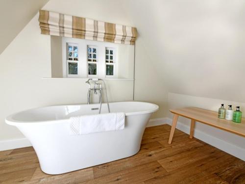 a white bath tub in a bathroom with a wooden floor at 3 Bed in Lockerbie oc-95861 in Brydekirk