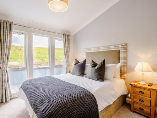 a bedroom with a large bed and two windows at 2 Bed in Newton Stewart oc-79129 in Gillespie
