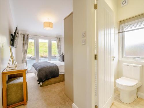 a bedroom with a bed and a toilet and a window at 2 Bed in Newton Stewart oc-79129 in Gillespie