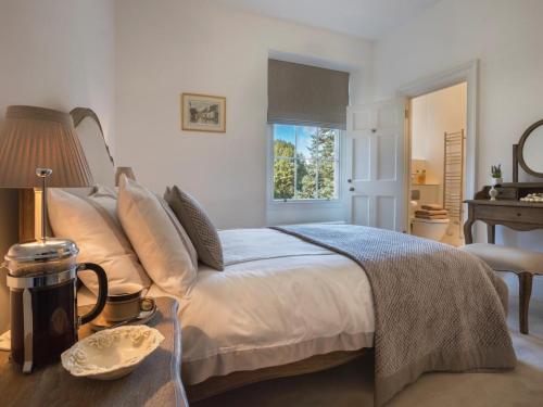 a bedroom with a bed and a table with a lamp at 1 Bed in Spark Bridge oc-lcc52 in Spark Bridge