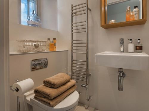 a bathroom with a toilet and a sink and towels at 1 Bed in Spark Bridge oc-lcc52 in Spark Bridge