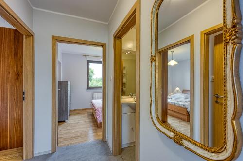 a bathroom with a mirror and a bedroom at Apartma pri Cesarjevih in Sežana