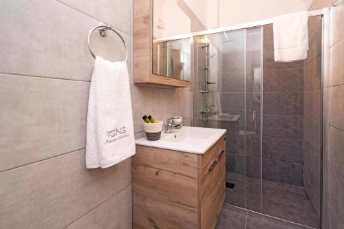 a bathroom with a sink and a shower at Villa Michou Helios by Villa Plus in Lourdata