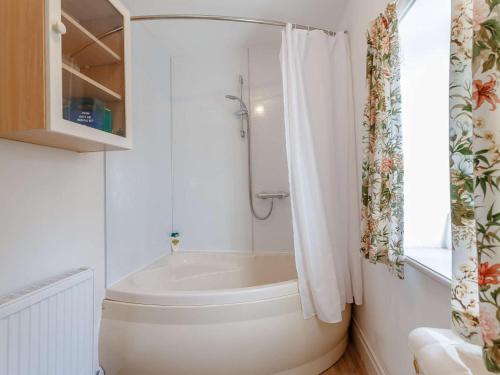 a white bathroom with a tub and a shower at 3 Bed in Turriff oc-75489 in Turriff