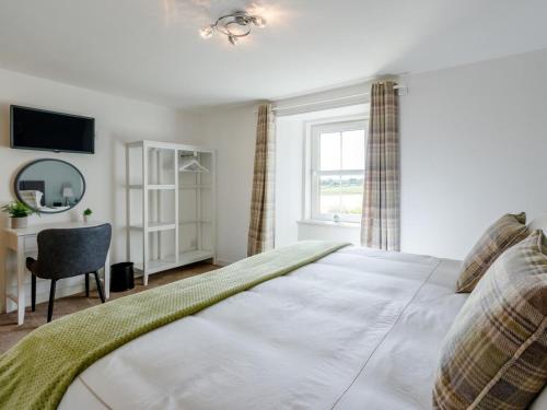 a bedroom with a bed and a desk and a window at 3 Bed in Crieff oc-78313 in Madderty