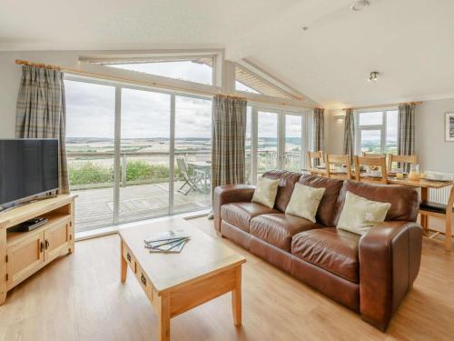a living room with a brown leather couch and a television at 3 Bed in St. Andrews oc-88420 in Balmullo