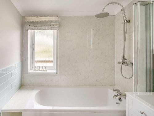 a white bathroom with a tub and a window at 3 Bed in St. Andrews oc-88420 in Balmullo