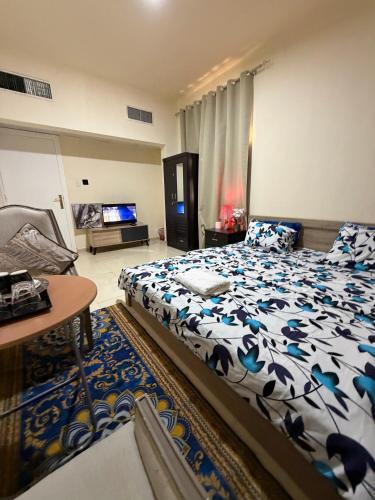 a bedroom with a bed and a table and a television at MAMA DELiGHT HOME in Abu Dhabi