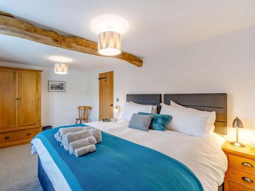 a bedroom with a large bed with blue and white sheets at 3 Bed in Wigton oc-86087 in Caldbeck