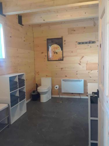 a log cabin with a toilet in a room at #5 Le Repère Aux Corbeaux in Saint-Onésime
