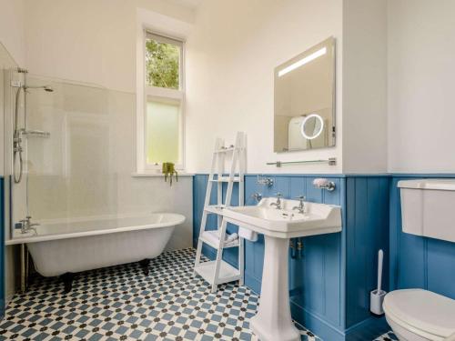 a bathroom with a tub and a sink and a toilet at 1 Bed in Langholm oc-83343 in Langholm