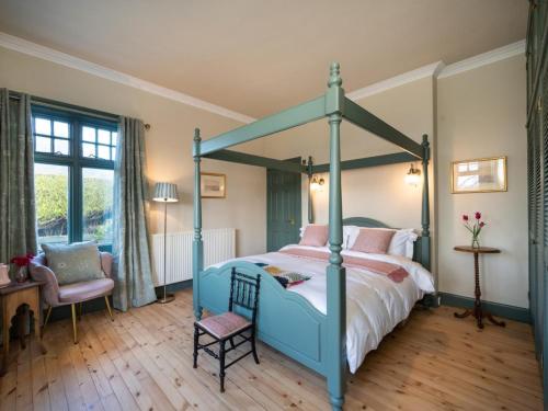 a bedroom with a blue canopy bed and a chair at 3 Bed in Gullane oc-96141 in Gullane