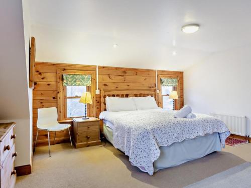a bedroom with a bed and a chair in it at 3 Bed in Fort William oc-95783 in Torlundy