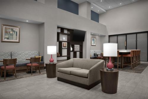 a lobby with a couch chair and a piano at Hampton Inn & Suites Lakeland-South Polk Parkway in Lakeland