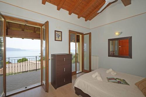 a bedroom with a bed and a balcony at Villetta Enzo - Gardagate in Toscolano Maderno