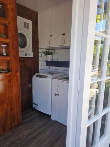 a kitchen with a stove and a washer and dryer at Livingstone Retreat in Hokitika