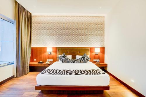 a bedroom with a large bed with a zebra print headboard at Sunday Resort & Spa Manesar by CheckIn, Gurugram in Gurgaon
