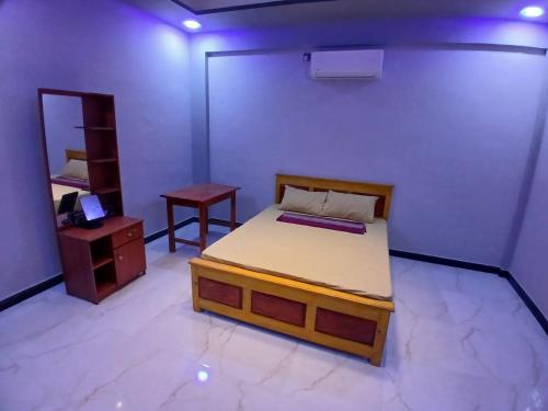 a bedroom with a bed and a table and a mirror at AR villa in Jaffna