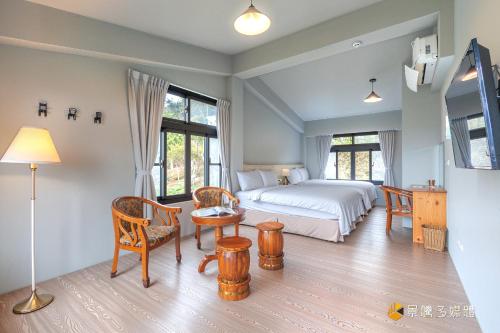 a bedroom with a bed and a table and chairs at Bi La Homestay in Luye