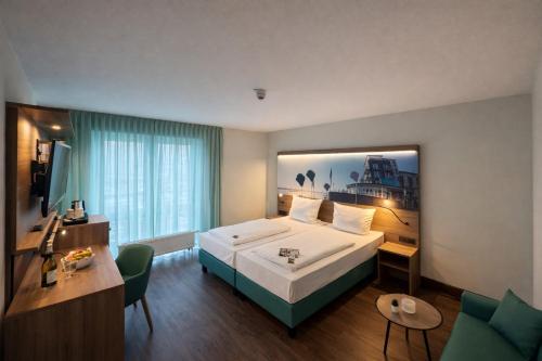 a hotel room with a bed and a desk at Hotel Rheinpark Rees in Rees