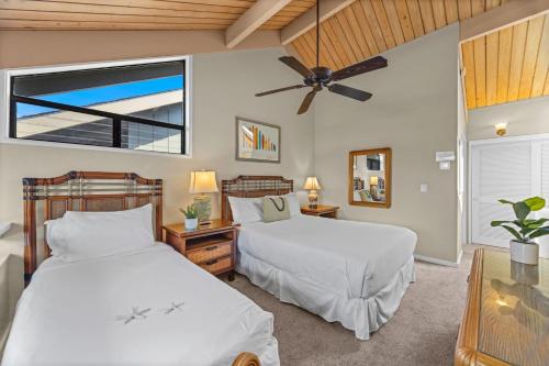 two beds in a bedroom with a ceiling fan at Kahana Village 9 · KHV 9 2BR Oceanfront Condo w Panoramic Maui in Lahaina