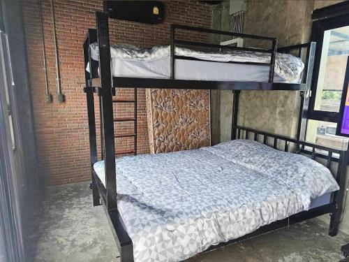 a bedroom with two bunk beds and a brick wall at Navy Medic 36 Poolvilla in Sattahip
