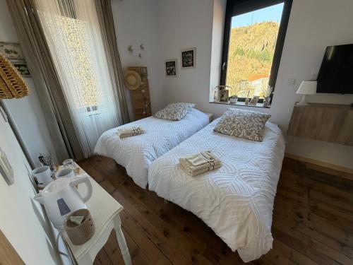 two beds in a room with a window at L'Etape des Jacquets - Monistrol d'allier in Monistrol-dʼAllier