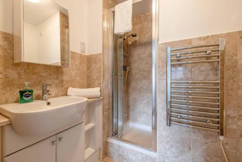 a bathroom with a sink and a shower at 2 BED 2 BATH with PARKING NEAR PINEWOOD, WEXHAM HOSPITAL - By Tempstay in Slough
