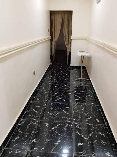 a hallway with a black marble floor in a room at Aduniniyi 7 Shines in Igando