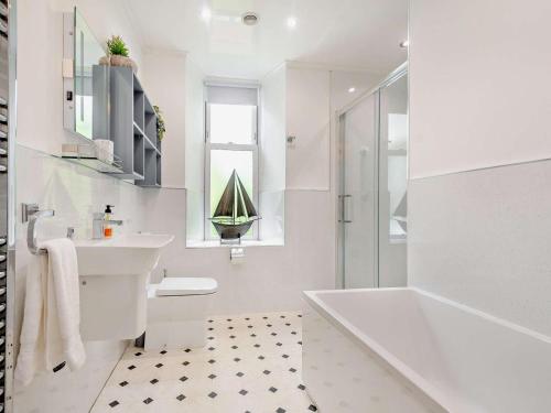 a white bathroom with a tub and a sink at 3 Bed in Langholm oc-95053 in Langholm