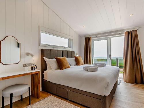 a bedroom with a large bed with a desk and a window at 2 Bed in Anstruther oc-83174 in Anstruther
