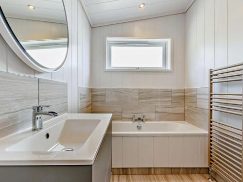 a bathroom with a sink and a tub and a mirror at 2 Bed in Anstruther oc-83174 in Anstruther
