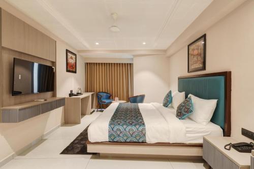 a hotel room with a bed and a flat screen tv at Hotel Ramida Suites IGI Delhi Airport in New Delhi