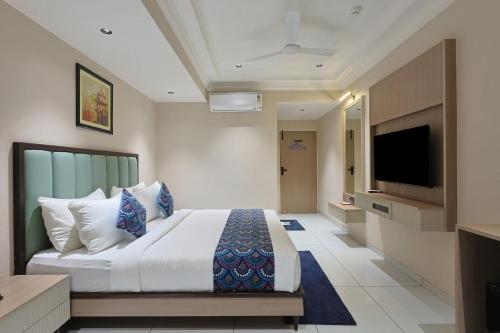 a bedroom with a large bed and a flat screen tv at Hotel Ramida Suites IGI Delhi Airport in New Delhi