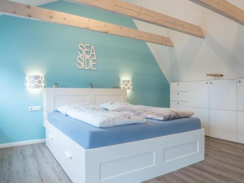 a bedroom with a white bed and blue walls at Hafensternchen in Husum
