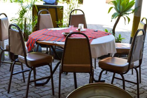 uma mesa com cadeiras e uma toalha de mesa vermelha e branca em West Park Hotel em Nairobi