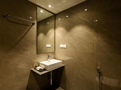 a bathroom with a sink and a mirror at Hotel Rio in Siliguri