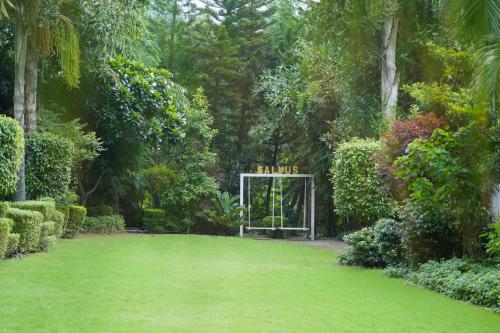 a garden with a gate with a sign that reads panic at Narayana Sanctuary Resort by SALVUS in Rishīkesh