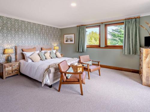 a bedroom with a large bed and two chairs at 6 Bed in Perth oc-96289 in Stanley