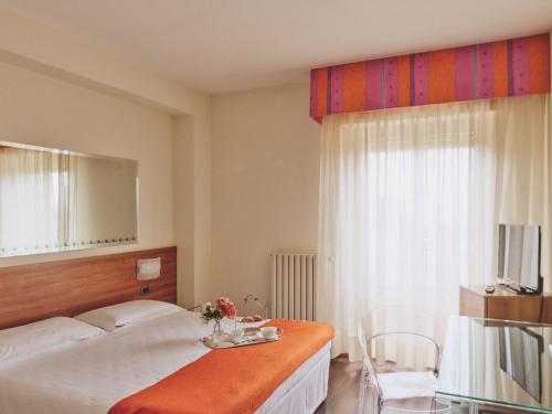 a bedroom with a bed and a table and a window at Ilgo Hotel in Perugia