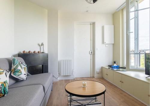 a living room with a couch and a table at L'espace de Robespierre in Saint-Denis
