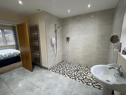 a bathroom with a shower and a sink and a tub at Copperbeech Farm Cottages in Maze