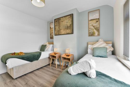 a bedroom with two beds and a table at Delves House in Bescot
