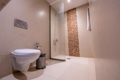 a bathroom with a toilet and a walk in shower at Al Muhaidb Residence Al Malaz 3 - Economic in Riyadh