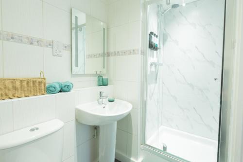 a white bathroom with a sink and a shower at Spacious City Centre Apartment with Balcony in Wolverhampton