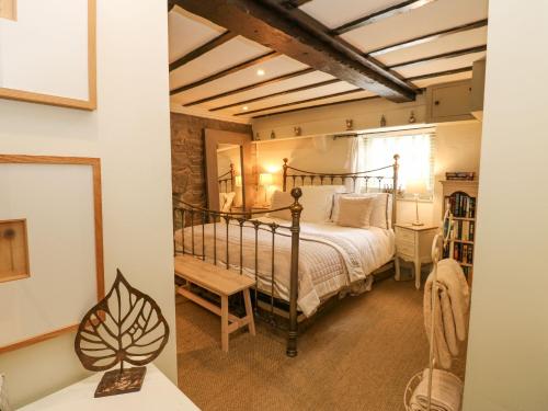 a bedroom with a bed and a desk in a room at In & Out Cottage in Leyburn