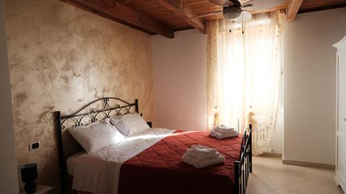 a bedroom with a bed with a red blanket and a window at La casa del tulipano in Bernalda