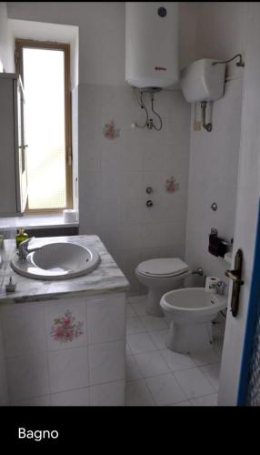 a bathroom with a sink and a toilet and a window at Grande Procida in Procida