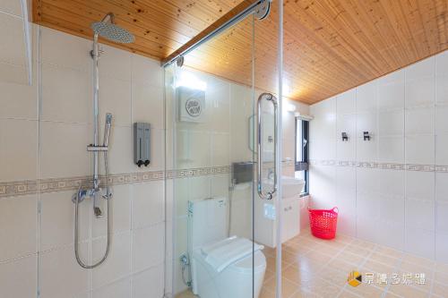 a bathroom with a shower and a toilet at Bi La Homestay in Luye